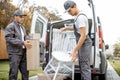 Delivery company employees unloading cargo van vehicle Royalty Free Stock Photo