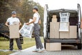 Delivery company employees unloading cargo van vehicle Royalty Free Stock Photo