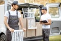 Delivery company employees unloading cargo van vehicle Royalty Free Stock Photo