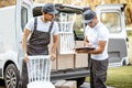 Delivery company employees unloading cargo van vehicle Royalty Free Stock Photo