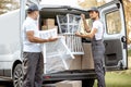 Delivery company employees unloading cargo van vehicle Royalty Free Stock Photo