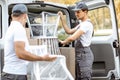 Delivery company employees unloading cargo van vehicle Royalty Free Stock Photo