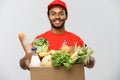 Delivery Concept - Handsome African American delivery man carrying package box of grocery food and drink from store Royalty Free Stock Photo