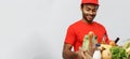 Delivery Concept - Handsome African American delivery man carrying package box of grocery food and drink from store Royalty Free Stock Photo