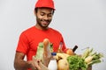 Delivery Concept - Handsome African American delivery man carrying package box of grocery food and drink from store Royalty Free Stock Photo