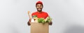 Delivery Concept - Handsome African American delivery man carrying package box of grocery food and drink from store Royalty Free Stock Photo