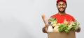 Delivery Concept - Handsome African American delivery man carrying package box of grocery food and drink from store Royalty Free Stock Photo