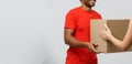 Delivery Concept - Handsome African American delivery man giving package to homeowner. Isolated on Grey studio Royalty Free Stock Photo