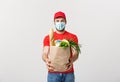 Delivery Concept - Handsome Cacasian delivery man carrying package bag of grocery food and drink from store. Isolated on Royalty Free Stock Photo