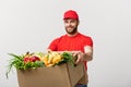 Delivery Concept - Handsome Cacasian delivery man carrying package box of grocery food and drink from store. Isolated on Royalty Free Stock Photo