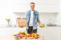 Delivery Concept - Handsome Cacasian delivery man carrying package box of grocery food and drink from store. Copy Space. Royalty Free Stock Photo