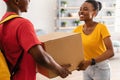 Happy African American Woman Receiving Box From Courier At Home Royalty Free Stock Photo