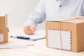 Delivery concept. Man signs papers among parcels Royalty Free Stock Photo