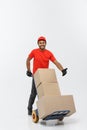 Delivery Concept - Portrait of Handsome African American delivery man or courier pushing hand truck with stack of boxes Royalty Free Stock Photo