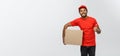 Delivery Concept - Portrait of Happy African American delivery man holding a box package and showing thumps up. Isolated Royalty Free Stock Photo