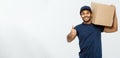 Delivery Concept - Portrait of Happy African American delivery man holding a box package and showing thumps up. Isolated Royalty Free Stock Photo