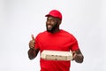 Delivery Concept - Portrait of Happy African American delivery man holding a pizza box package and showing thumbs up Royalty Free Stock Photo