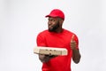 Delivery Concept - Portrait of Happy African American delivery man holding a pizza box package and showing thumbs up Royalty Free Stock Photo