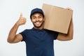 Delivery Concept - Portrait of Happy African American delivery man holding a box package and showing thumps up. Isolated Royalty Free Stock Photo
