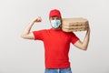 Delivery Concept - Portrait of Strong handsome delivery man flexing his muscle and holding pizza box packages. Isolated