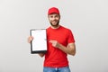 Delivery Concept: Portrait Young caucasian Handsome delivery man or courier showing a confirmation document form to sign Royalty Free Stock Photo