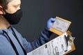 Delivery of correspondence during the period of self-isolation. A man in rubber gloves and a mask holding a delivered letter and a Royalty Free Stock Photo