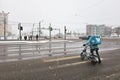 delivery courier crosses a pedestrian crossing on a bicycle on a road