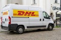 Delivery by DHL. White minibus on the street, delivery of settlements and documents. Poland, Warsaw - July 26, 2023