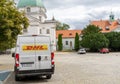 Delivery by DHL. White minibus on the street, delivery of settlements and documents. Poland, Warsaw - July 26, 2023