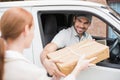 Delivery driver handing parcel to customer in his van Royalty Free Stock Photo