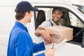 Delivery driver handing parcel to customer in his van Royalty Free Stock Photo