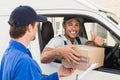 Delivery driver handing parcel to customer in his van Royalty Free Stock Photo