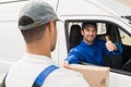 Delivery driver handing parcel to customer in his van Royalty Free Stock Photo