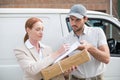 Delivery driver handing parcel to customer outside van Royalty Free Stock Photo