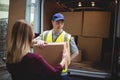 Delivery driver handing parcel to customer outside van Royalty Free Stock Photo