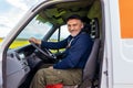 Delivery driver looking out the window of the white cargo van vehicle, delivering goods by car Royalty Free Stock Photo