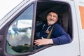 Delivery driver looking out the window of the white cargo van vehicle, delivering goods by car Royalty Free Stock Photo