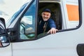 Delivery driver looking out the window of the white cargo van vehicle, delivering goods by car Royalty Free Stock Photo