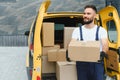 Delivery driver unloading cardboard boxes from van Royalty Free Stock Photo