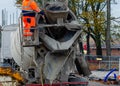 Delivery driver washing concrete vagon after delivering concrete on building site