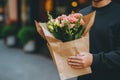 Delivery employee person courier man male hands holding groceries paper bags bouquet beautiful fresh flowers outdoors