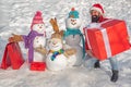 Delivery gifts. Happy winter snowman family. Mother snow-woman, father snow-man and kid wishes merry Christmas and Happy
