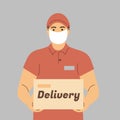 Delivery of goods during the prevention of coronovirus, Covid-19. Courier in a face mask with a box in his hands. Portrait from