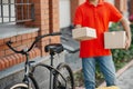 Delivery of goods to door of house. Client received parcel from courier with bicycle