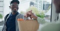 Delivery, grocery and bag with a black man courier at the front door of a home to drop off produce for a customer. Food Royalty Free Stock Photo