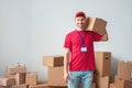 Delivery guy on white wall standing holding box on shoulder strong happy Royalty Free Stock Photo