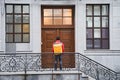 Delivery guy with termo backpack waiting for the door to open Royalty Free Stock Photo