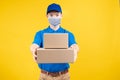 Delivery handsome man wearing and pointing mask with carton box picking up the package Royalty Free Stock Photo