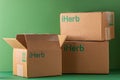 Delivery of Iherb vitamins by mail. Cardboard boxes with green logo. Open box. Shopping online