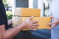 Delivery mail man giving parcel box to recipient, Young owner accepting of cardboard boxes package from post shipment, Home Royalty Free Stock Photo